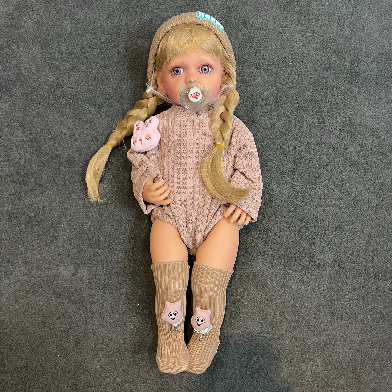 عروسک سیلیکونی وینیل واقعی ۲۲ اینچی(۵۵ سانتیمتر) با لباس کاموایی قهوه ای رنگ  و جوراب عروسکی و کلاه قهوه ای  به همراه لوازم جانبی برای سن +۳ Image