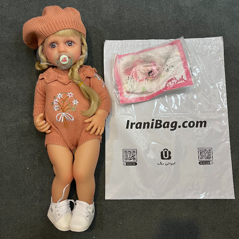 عروسک سیلیکونی وینیل واقعی ۲۲ اینچی(۵۵ سانتیمتر) با لباس کاموایی قهوه ای رنگ گل دار و کلاه به همراه لوازم جانبی برای سن +۳ Image