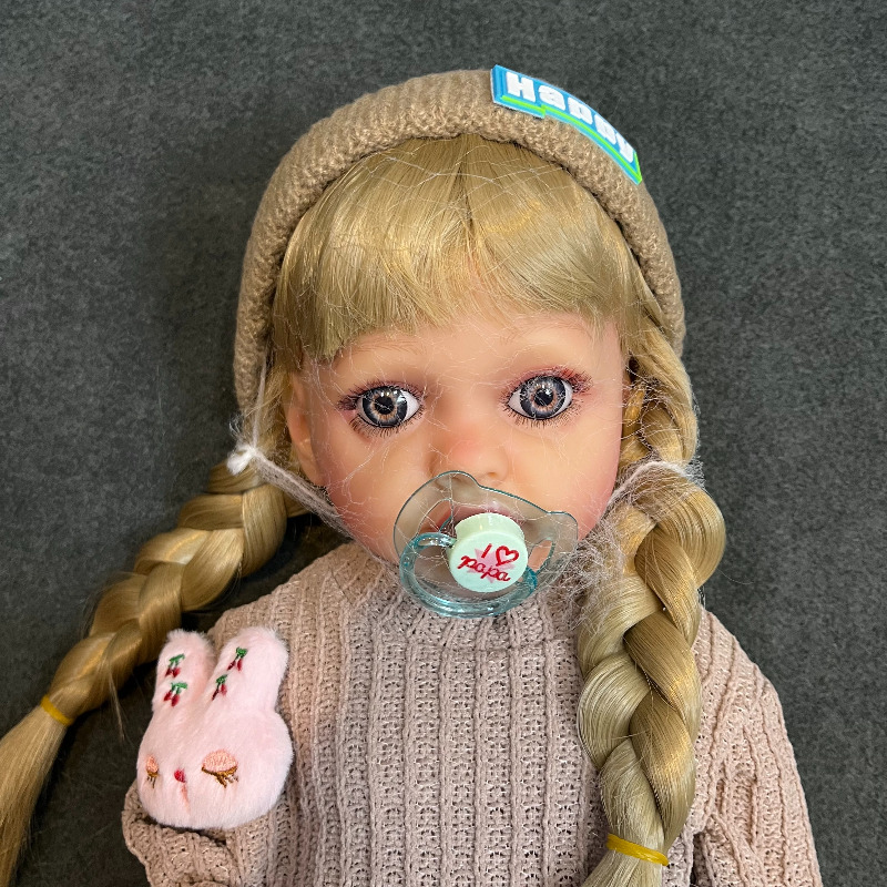 عروسک سیلیکونی وینیل واقعی ۲۲ اینچی(۵۵ سانتیمتر) با لباس کاموایی قهوه ای رنگ  و جوراب عروسکی و کلاه قهوه ای  به همراه لوازم جانبی برای سن +۳ Image
